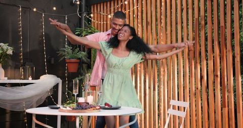 Happy couple dancing on patio during romantic outdoor dinner