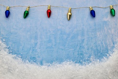 Festive string lights over snowy background for the holidays