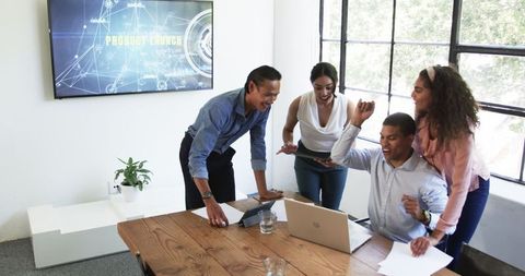 Diverse team celebrating successful meeting in modern office