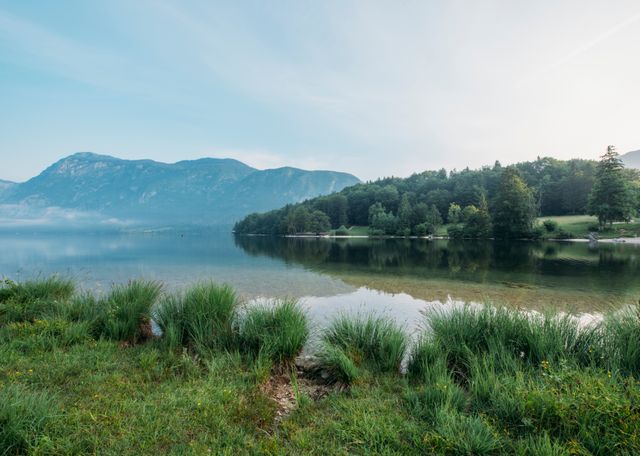 Serene Mountain Lake with Clear Sky and Green Shoreline - Download Free Stock Images Pikwizard.com