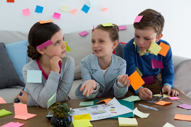 Kids as business executives playing with sticky notes in office
