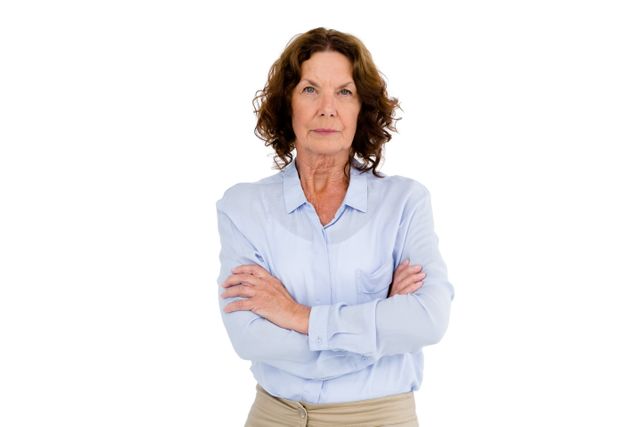 Serious mature woman with arms crossed while standing against white background