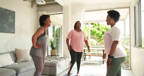 African American Friends Enjoying Relaxed Home Workout Session