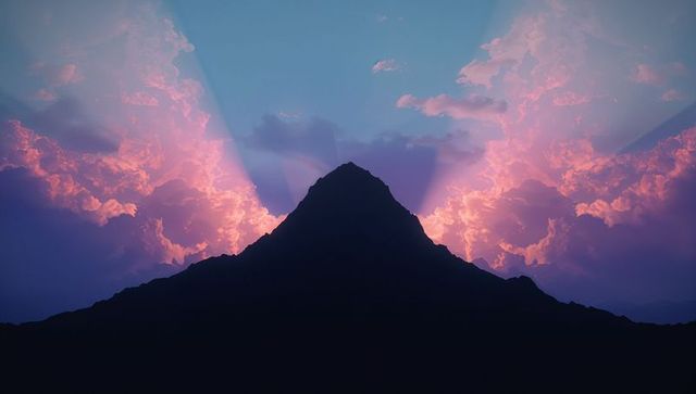Mountain peak silhouette at dawn with radiant light beams
