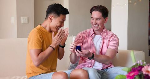 Happy Gay Couple Enjoying Gift Exchange in Living Room