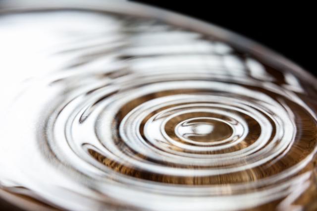This image captures a close-up view of water ripples with reflections, creating an abstract and tranquil scene. Ideal for use in projects related to nature, calmness, fluid dynamics, or abstract art. It can be used in websites, presentations, or advertisements to convey themes of serenity, motion, and natural beauty.