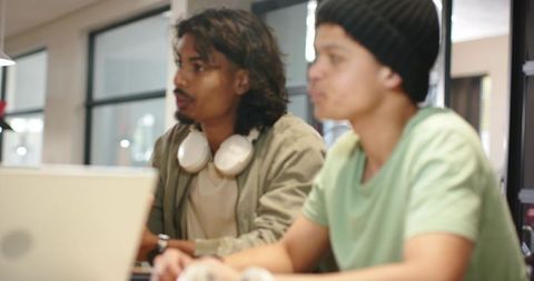 Young professionals collaborating over laptop in modern coworking space