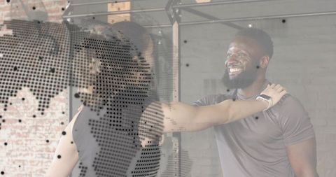 Bearded trainer coaching woman through shoulder stretch in industrial gym, smiling coach
