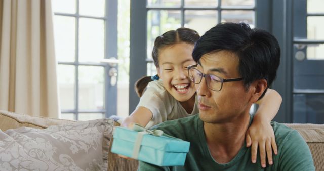 Smiling Girl Giving Present to Her Father at Home - Download Free Stock Images Pikwizard.com