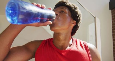 Young African American Man Hydrating After Intense Workout