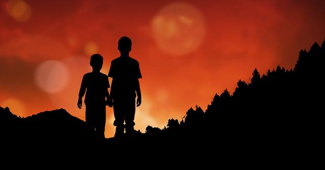 Digital composite of Silhouette children holding hands on mountain during sunset