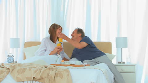 Couple Enjoying Breakfast in Bed with Joyful Connection