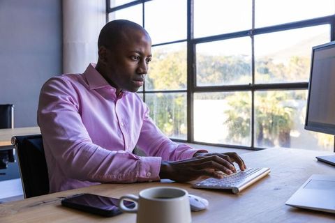 Focused professional typing on keyboard in office