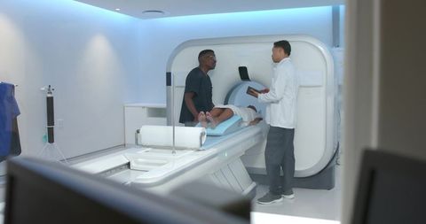 Multicultural radiology team preparing african american female patient for mri scan