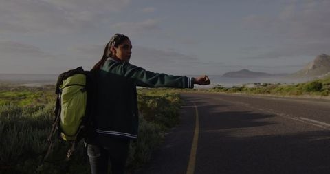 Woman Hitchhiking on Open Road in Scenic Landscape - Download Free Stock Images Pikwizard.com