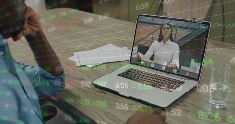 Professional watching virtual presenter on laptop with stock market data overlay