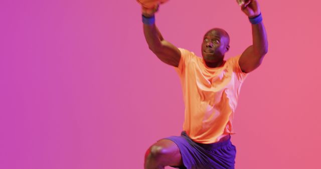 Man performing exercise with a medicine ball in a vibrant studio with colorful background. Excellent visuals for fitness blogs, workout routines, sports and health magazines, training programs, and dynamic posters.