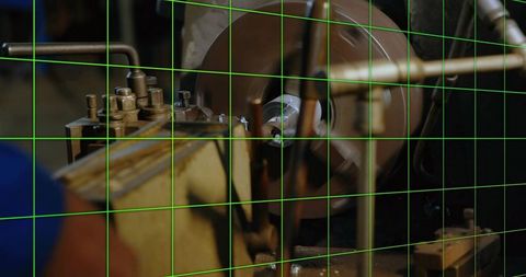 Lathe turning metal workpiece in 3-jaw chuck with cutting tool, metal chips and green grid