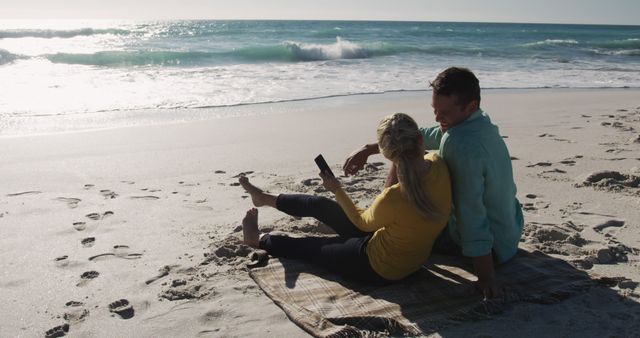 Couple Relaxing on Beach with Smartphone by Sunny Ocean - Download Free Stock Images Pikwizard.com