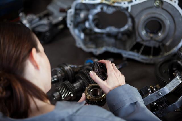 Female Mechanic Repairing Gear Mechanism in Workshop - Download Free Stock Photos Pikwizard.com