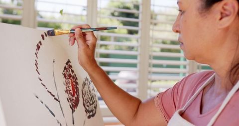 Woman Expresses Creativity Through Painting on Canvas at Home