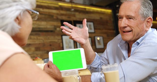 Senior Couple Discussing Over Green Screen Tablet in Cozy Cafe - Download Free Stock Images Pikwizard.com