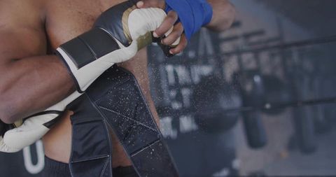 Male boxer adjusting wraps in gym training session