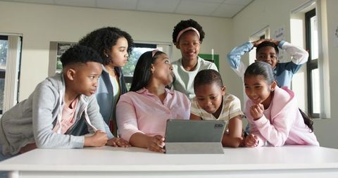 African American Teacher Leading Hands-On Tablet Lesson with Engaged Diverse Elementary Students