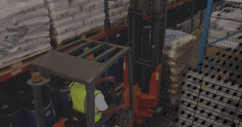 Forklift operator managing pallets in warehouse environment