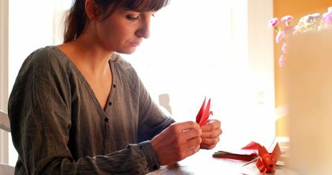 Caucasian Woman Creating Origami at Home in Bright Setting