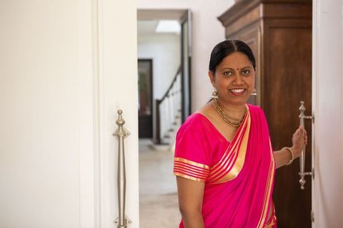 Elegant Senior Indian Woman in Pink Sari At Home Doorway