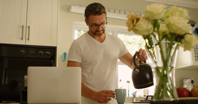 Man Pouring Coffee in Kitchen with Laptop - Download Free Stock Images Pikwizard.com