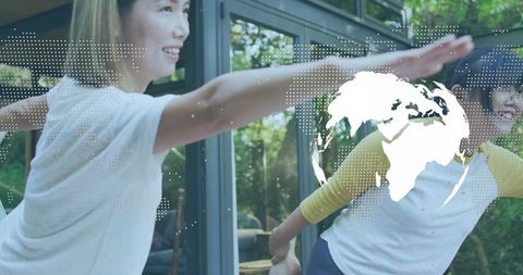 Mother and daughter balancing on glass sunroom porch with globe overlay and lush garden