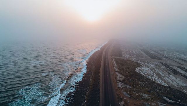 Winding highway along misty coastline at sunrise
