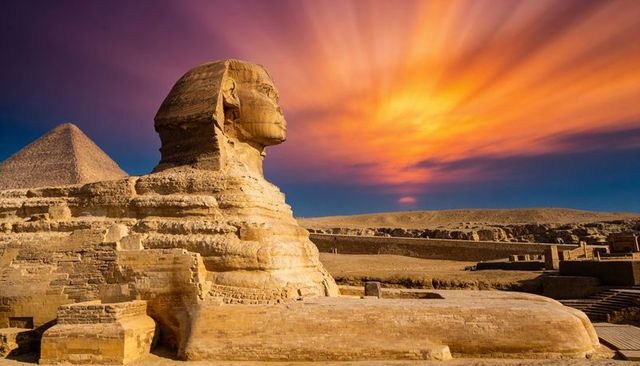 Great sphinx of giza at dramatic sunset with khafre pyramid and golden sky