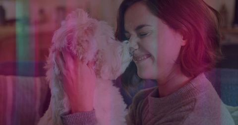 Woman Nuzzling Fluffy Puppy in Warm Living Room Environment