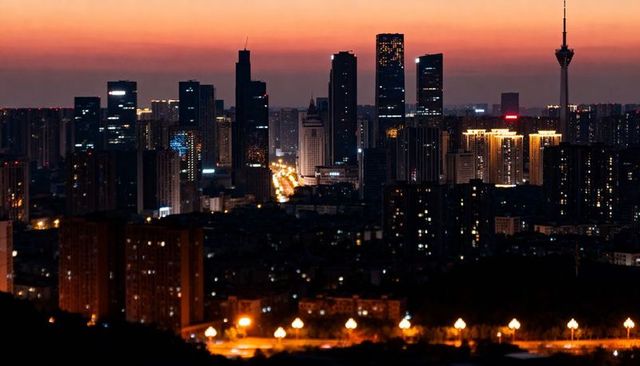 Glowing dusk skyline with lit avenue and tv tower, urban night panorama