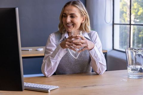 Serene Woman Working with Glass of Water in Bright Modern Office
