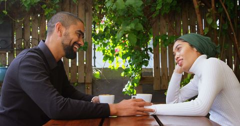 Middle eastern friends enjoying coffee and conversation outdoors