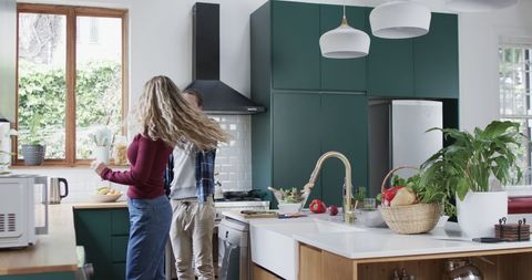 Happy Couple Dancing in Modern Kitchen at Home