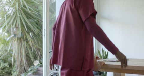 Caregiver assisting senior man in wheelchair at home