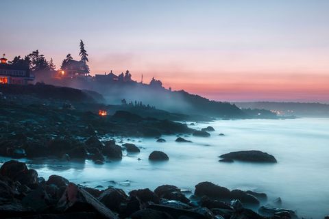 Scenic Rocky Coastline with Misty Pink Sunset and Calm Waves