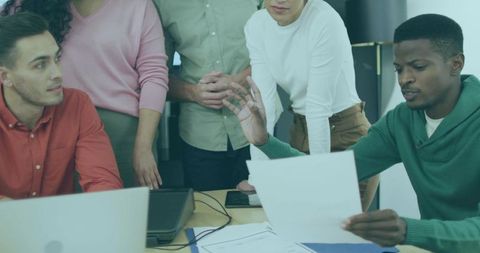 Diverse Team Engaging in Collaborative Office Discussion with Documents