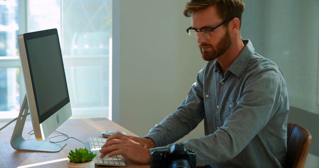 Man Working at Computer in Home Office with Camera - Download Free Stock Images Pikwizard.com