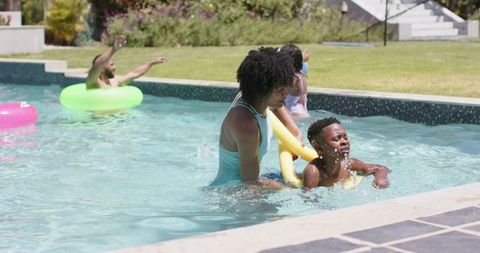 Mother Teaching Son to Swim with Noodle in Sunny Pool - Download Free Stock Images Pikwizard.com