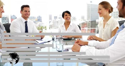 Corporate Team Collaborating Around Glass Boardroom Table with City Skyline