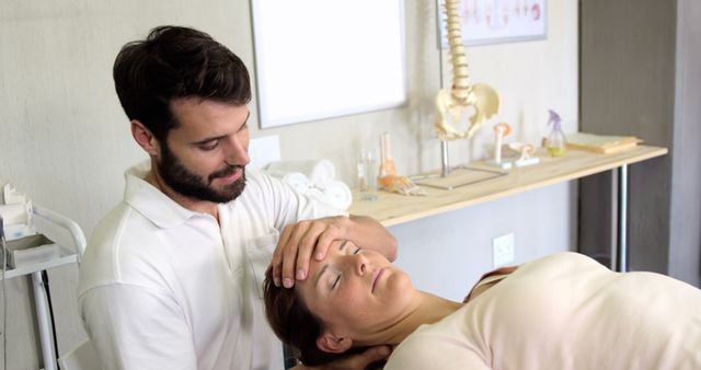 Physiotherapist performing neck therapy on lying female patient. Useful for healthcare, wellness, rehabilitation services, medical facilities, chiropractic offices, and physical therapy promotional materials.