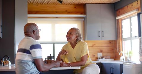 Senior African American Couple Enjoying Conversation in Bright Kitchen