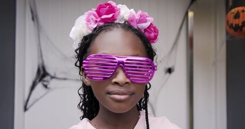 African american girl wearing pink flower crown and purple shutter shades on halloween