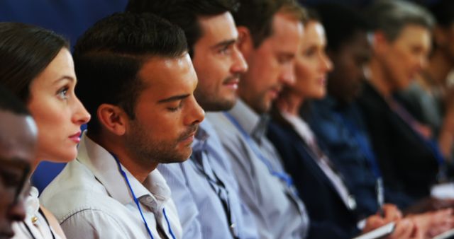 Image shows a diverse group of people with differing genders and ethnicities wearing casual business attire, attentively listening to a presentation. This visual can be used for corporate seminars, educational workshops, and meetings to emphasize themes of diversity, learning, and professional engagement.